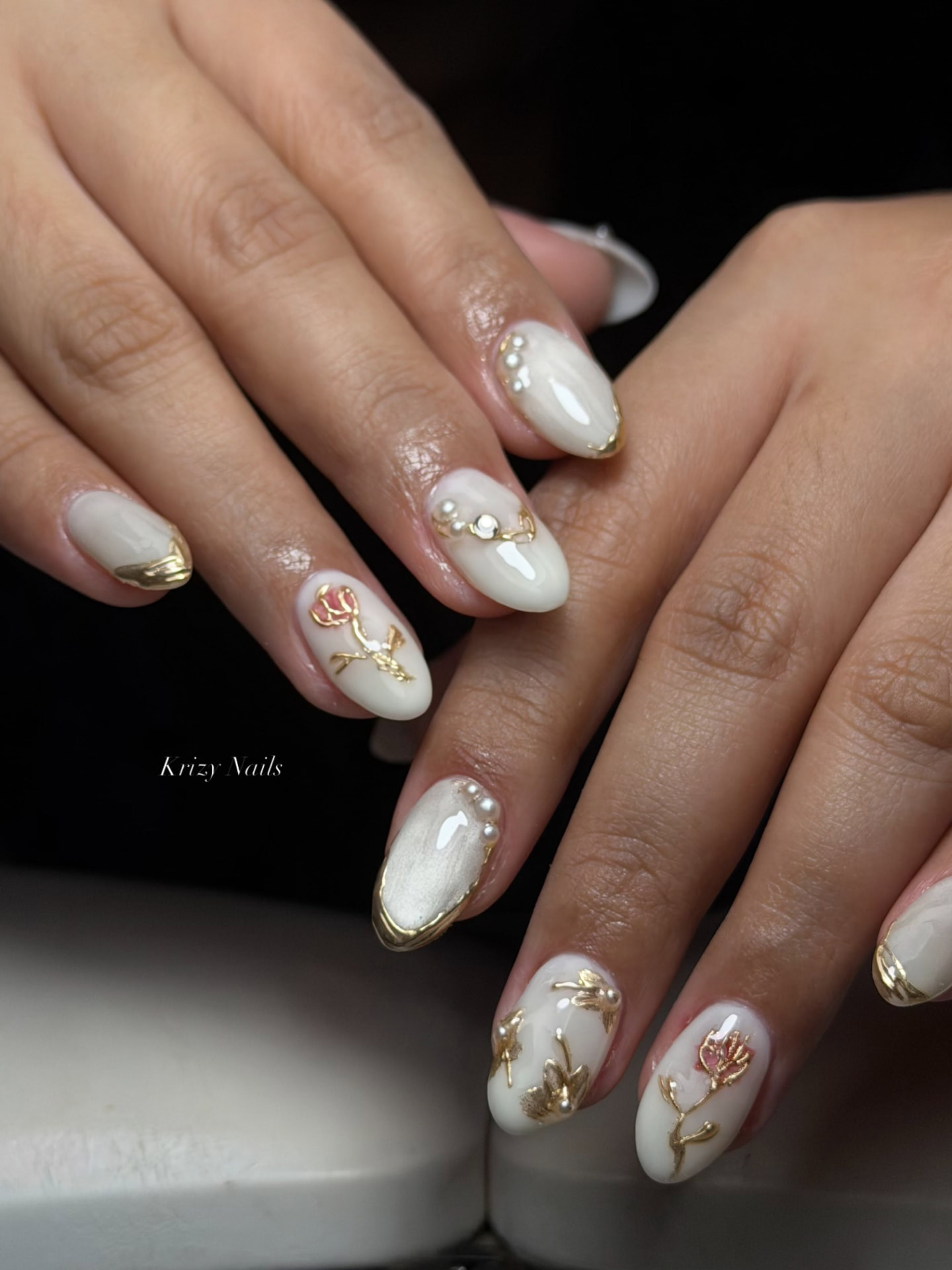 Gilded Blossom nail design — Milky base with gold chrome tips, pearls and sculpted florals.